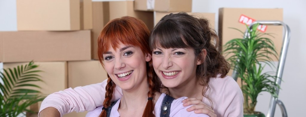 Two female flat-mates celebrating move
