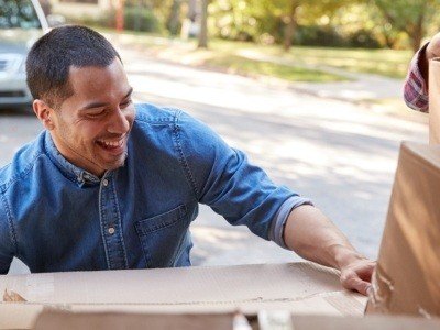 Couple Unloading Boxes From Van On Family Moving In Day