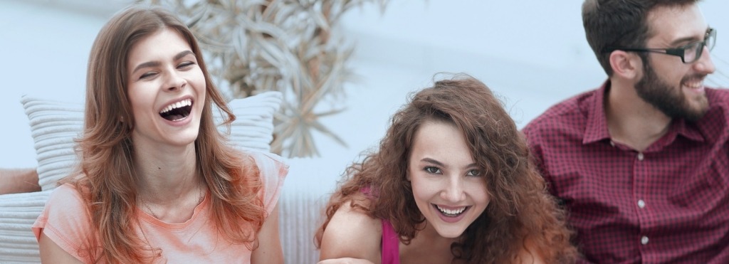 cheerful friends laughing in the living room.