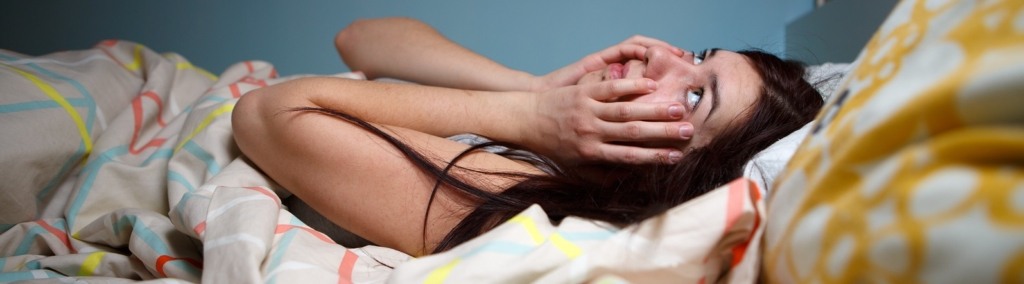 Young woman lying in bed suffering with insomnia Noisy neighbour, stress, alarm sound, prevent from sleep concept
