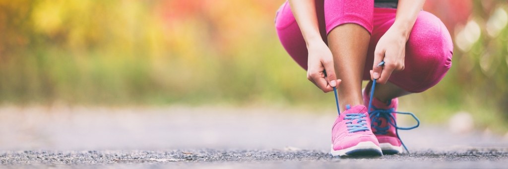 Running woman tying laces