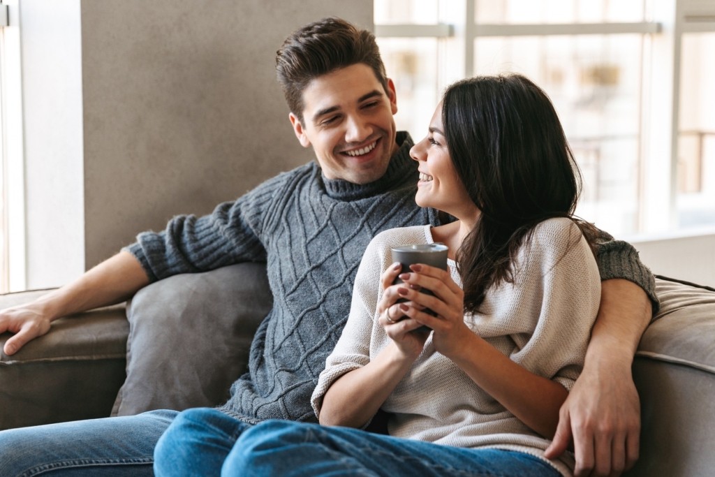 Loving couple cosy on sofa in small house