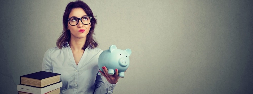 A female student holding textbooks & a piggy bank