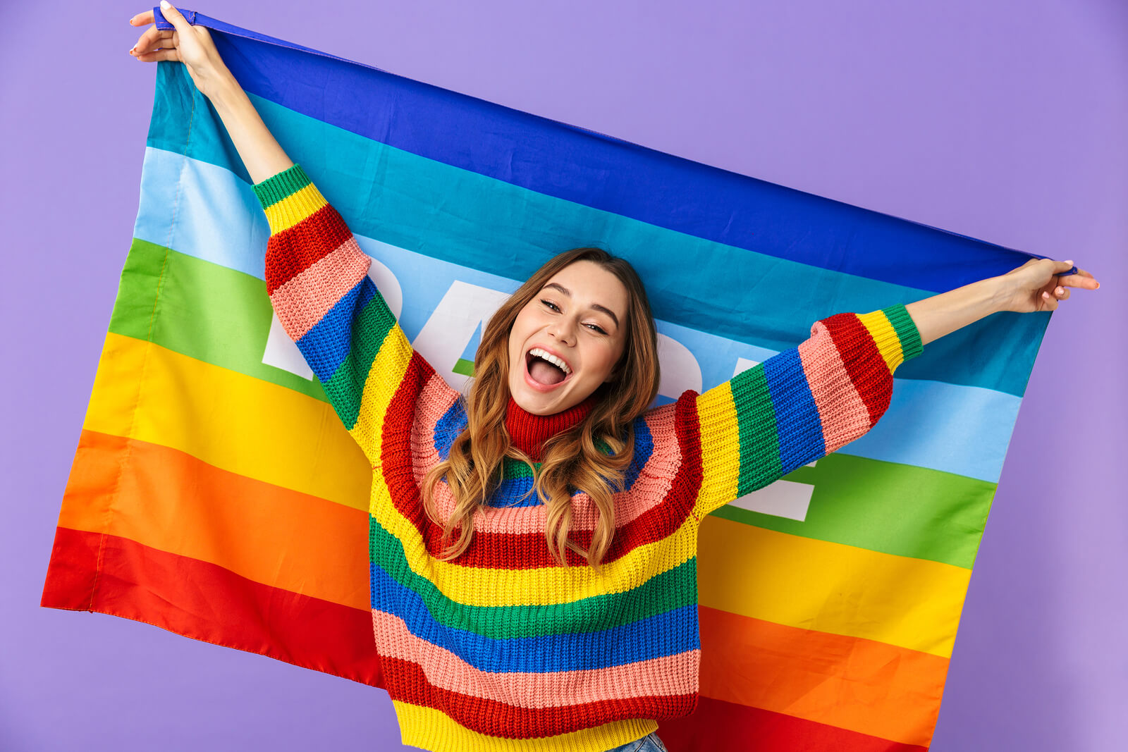 LGBTQ+ woman with rainbow flag and jumper