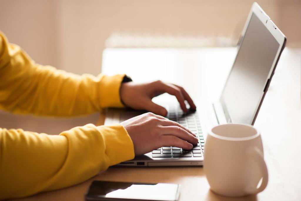the hands and keyboard of someone working from home