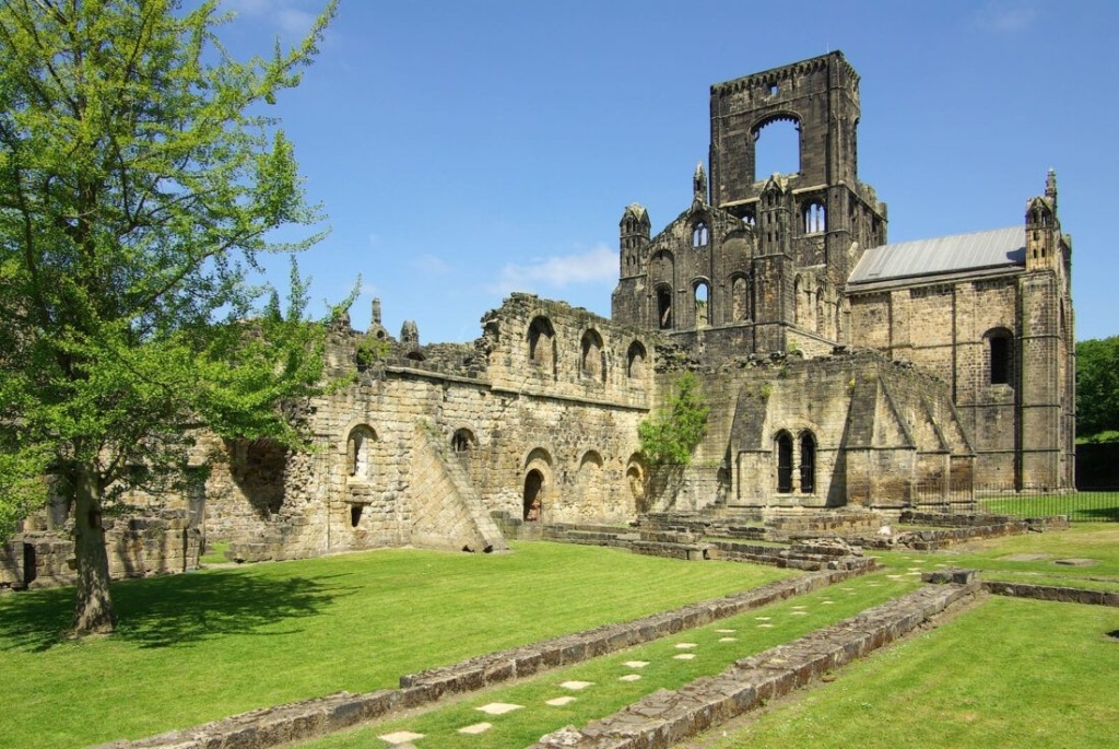 An image of Kirkstall Abbey in Leeds with a clear sky and sun shining.
