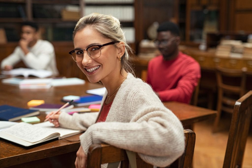 Photo of a student studying in a library with friends