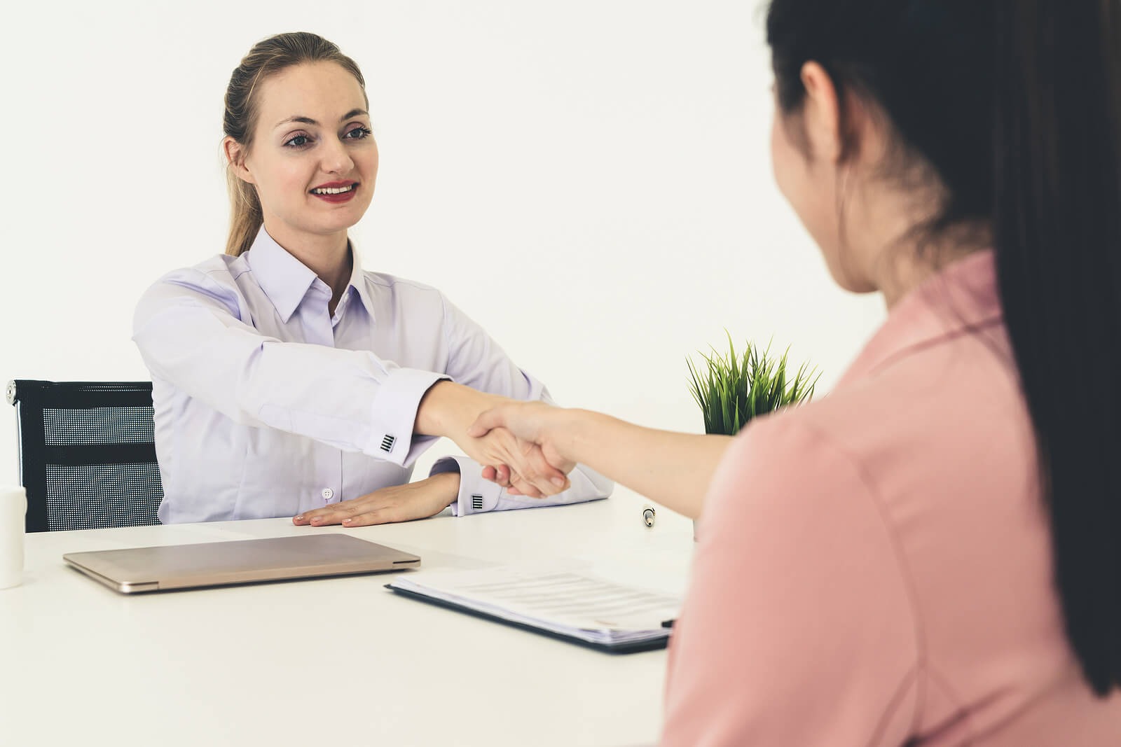 A successful graduate interview with handshake between two women