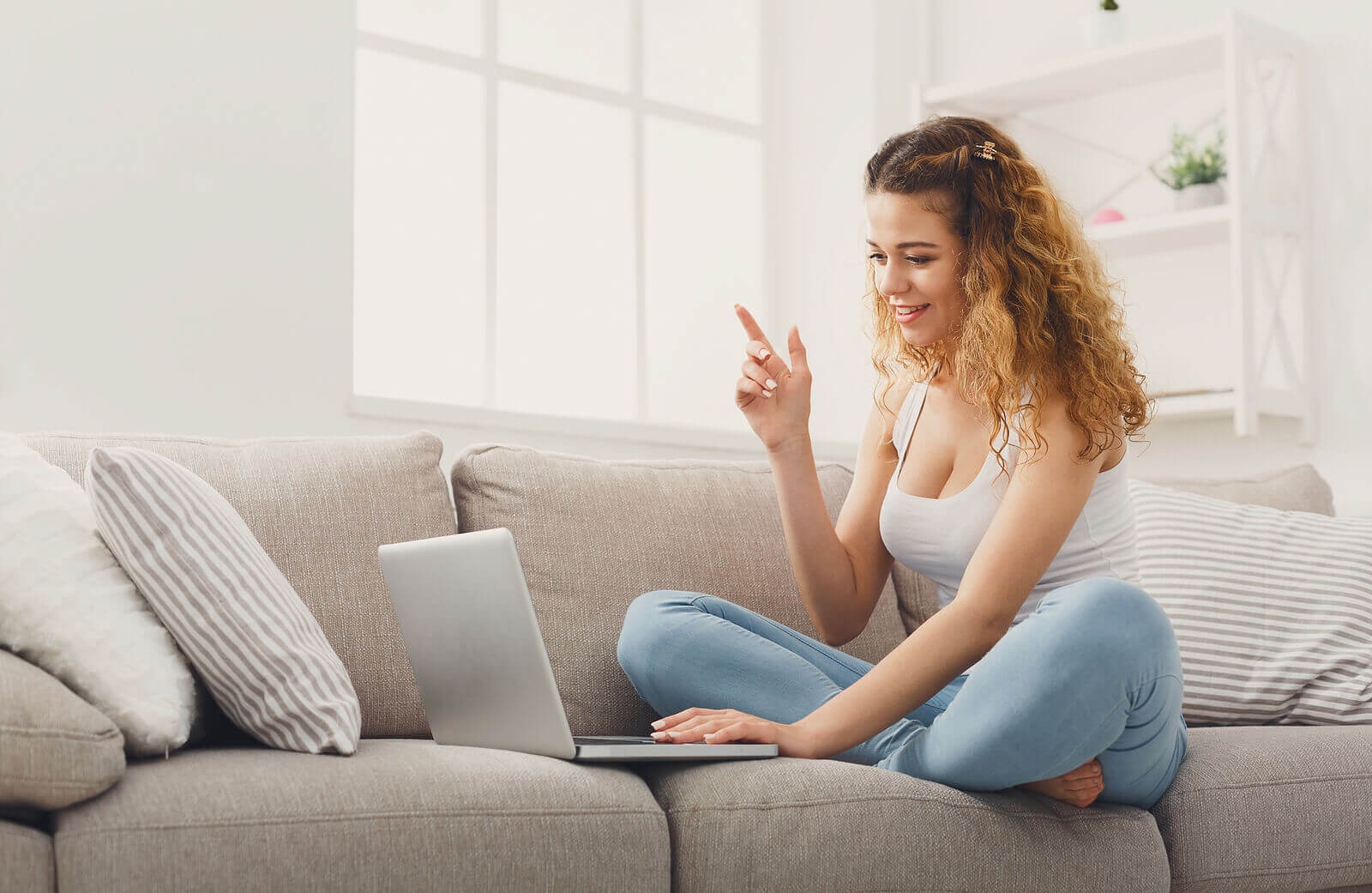 university student sat on sofa having video call on laptop with partner