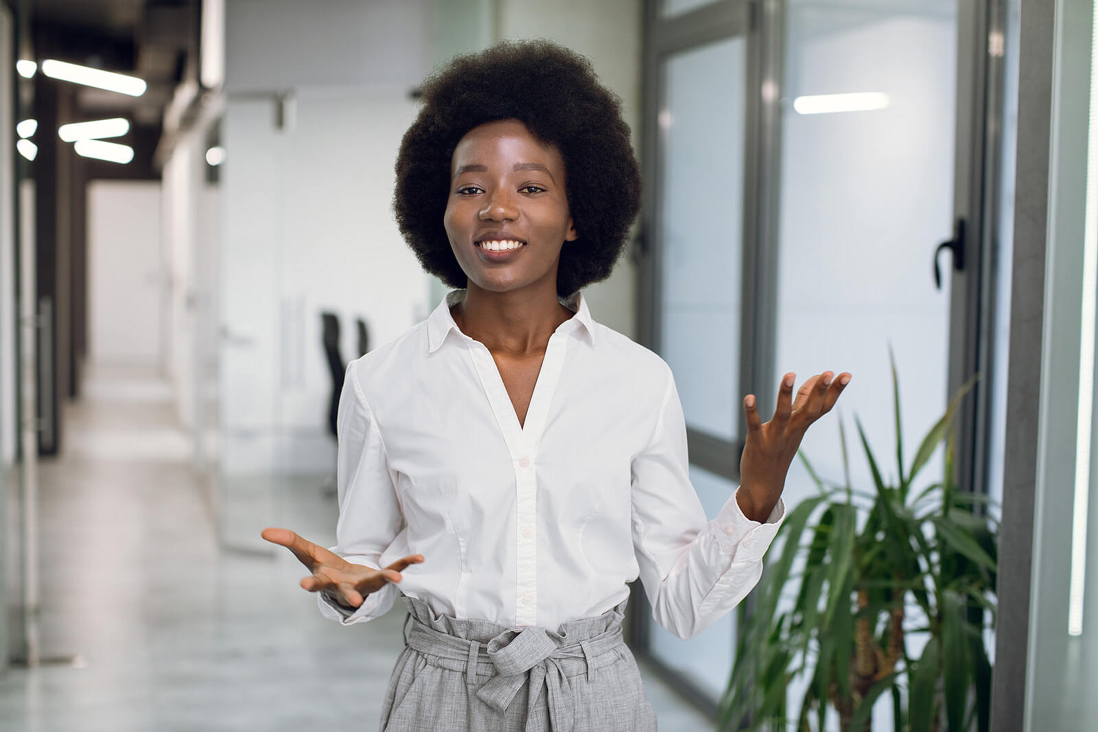 A young professional Black woman looking confident and stood in an office