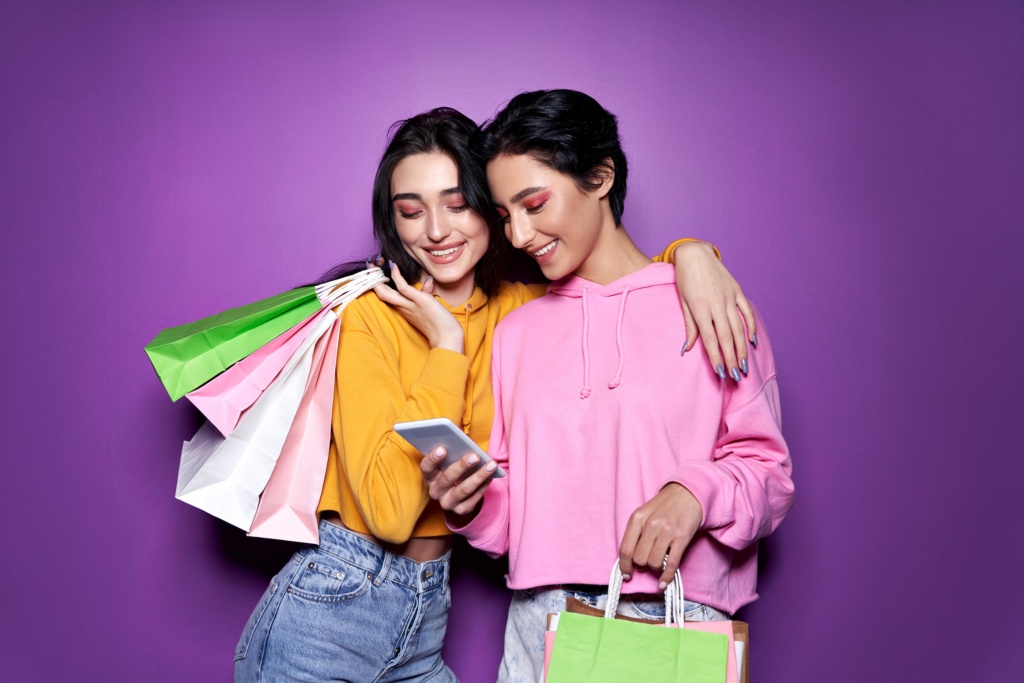 Two happy students holding shopping bags