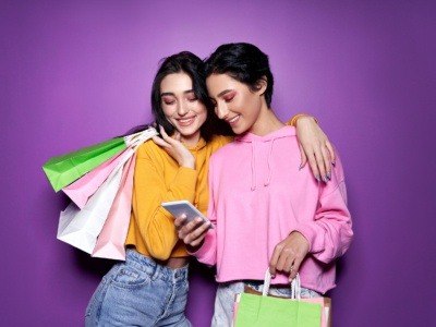 Two happy students holding shopping bags