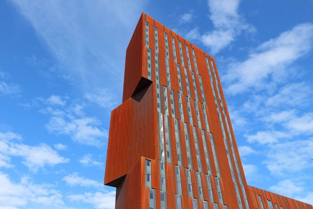 The building that houses the Faculty of Arts, Environment and Technology at Leeds Beckett University in the UK, with a blue sky and clouds as the backdrop.