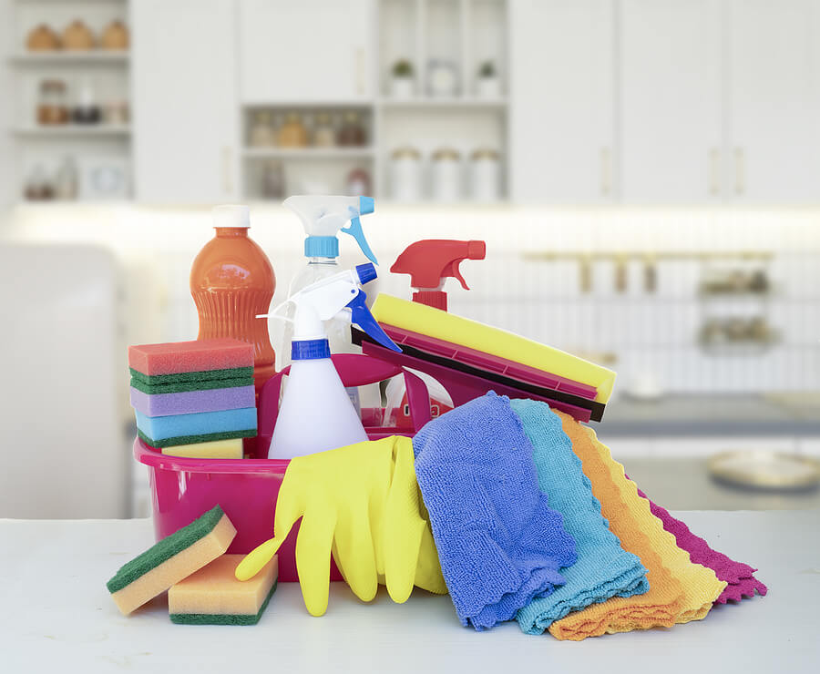cleaning supplies tools on spring tree bloom over kitchen background, spring clean concept