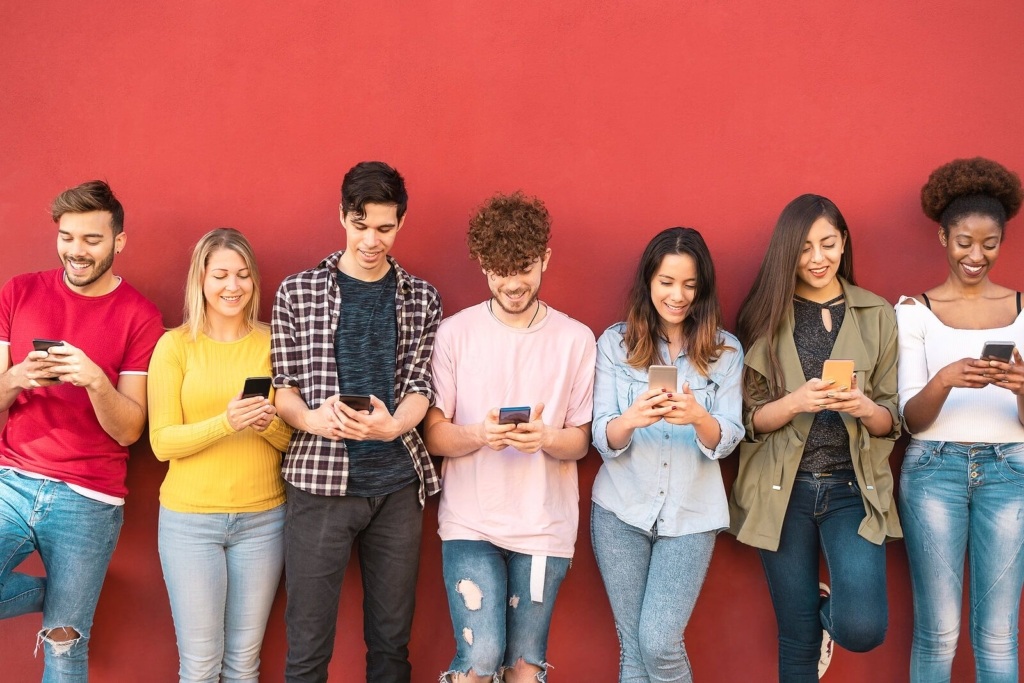Group young friends using mobile smartphone outdoor - Millennial generation having fun with new trends social media apps -