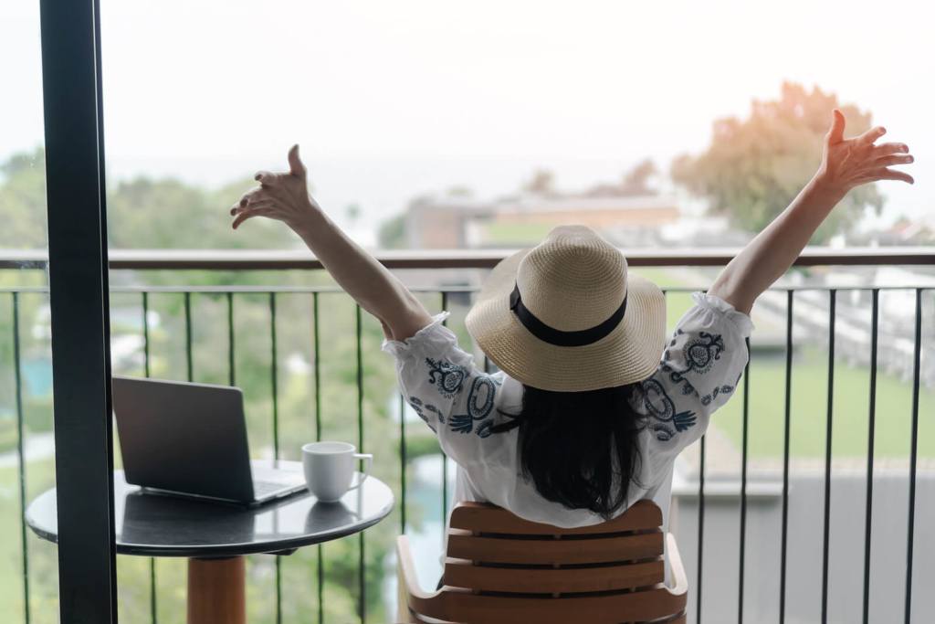 Work-life balance, summer holiday vacation concept with happy woman taking a break, celebrating success, work done, resting in luxury home or resort hotel balcony with computer laptop