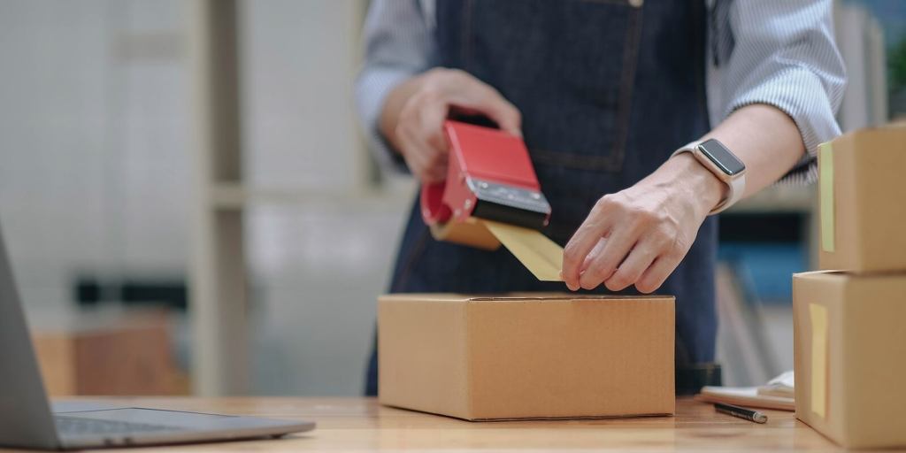 Shipping shopping online ,young start up small business owner writing address on cardboard box at workplace