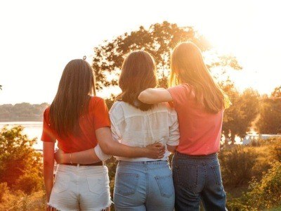 Summer Camp, Summer Classes, Friends University. Three cheerful girls friends dance and jump on summer sunset nature background. Group of friends on summer vacations