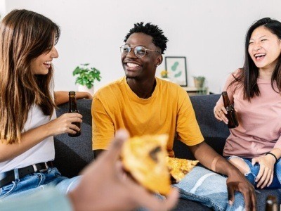 Young group of diverse best friends enjoying pizza together at home party - Millennial student people having fun together social gathering on apartment - Friendship