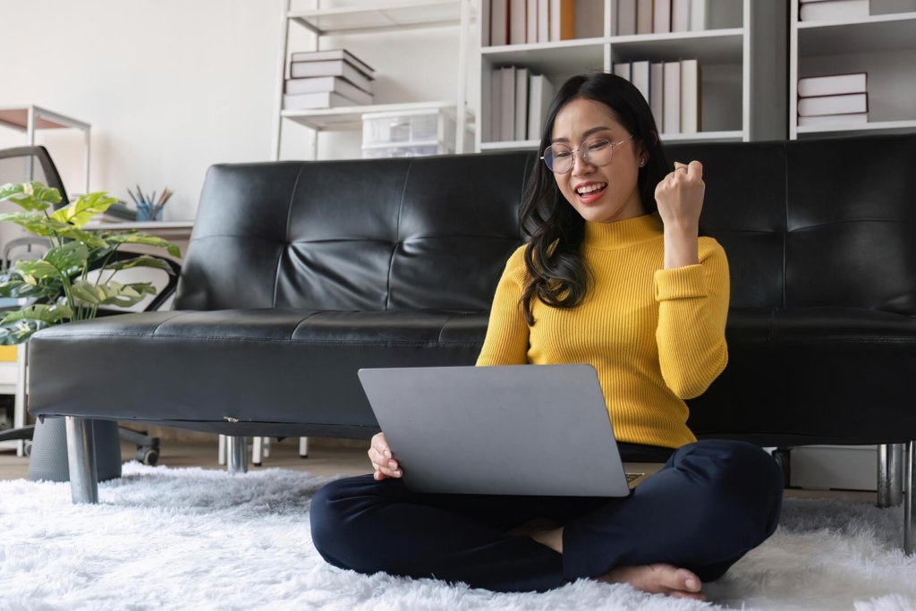 A young professional Asian woman celebrating career success.