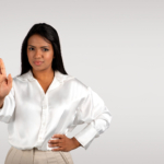 Black female professional saying no or stop at work with hand gesture.