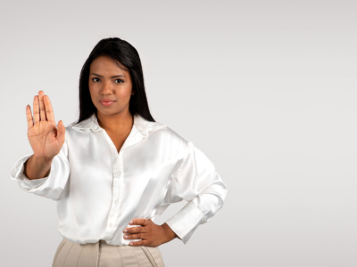 Black female professional saying no or stop at work with hand gesture.