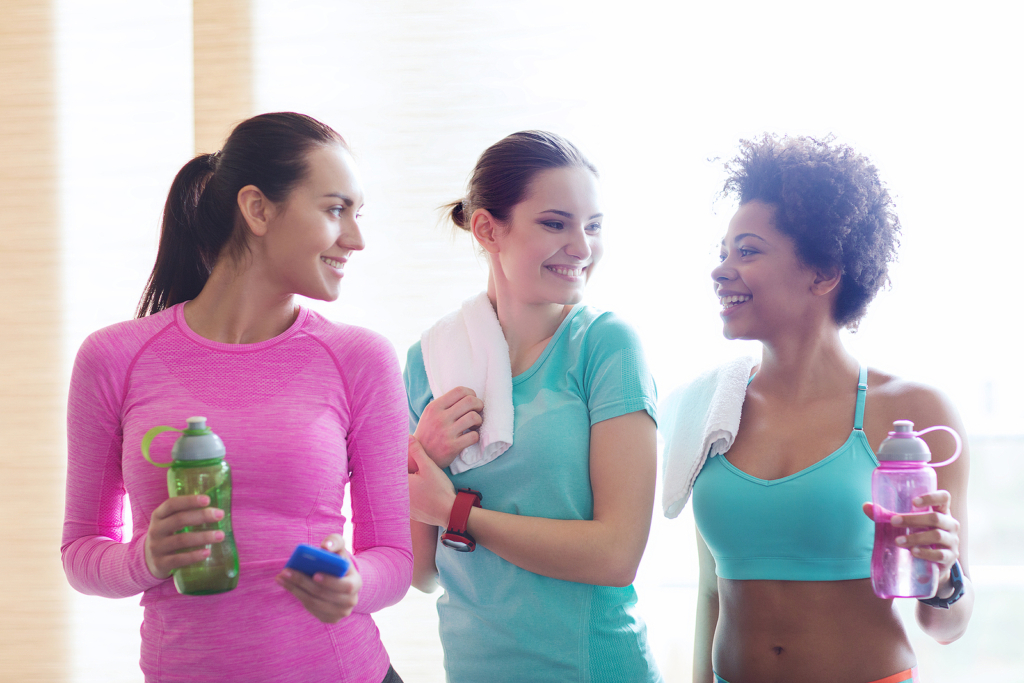 Three women chatting in the gym after or before a workout.