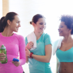 Three women chatting in the gym after or before a workout.