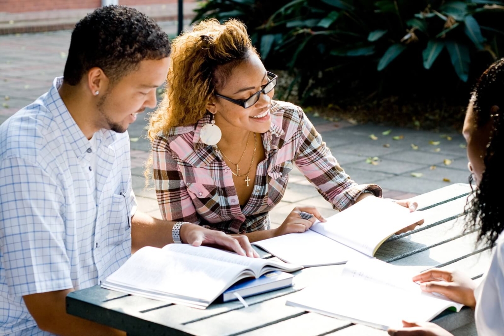 Three students studying together outdoors.