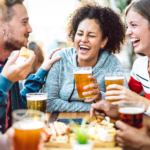 Student friends drinking lager on the Otley Run pub crawl in Leeds.