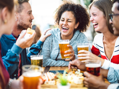 Student friends drinking lager on the Otley Run pub crawl in Leeds.
