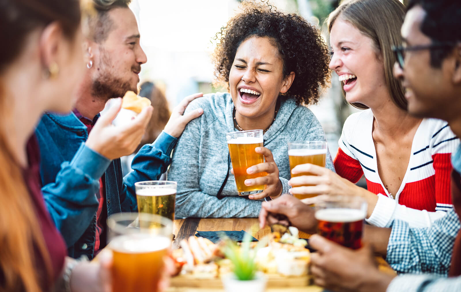 Student friends drinking lager on the Otley Run pub crawl in Leeds.
