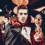A man and woman having fun in fancy dress costumes at a Halloween party in a bar.