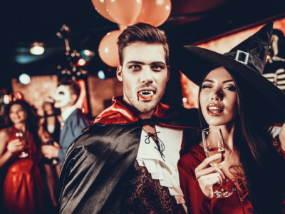 A man and woman having fun in fancy dress costumes at a Halloween party in a bar.