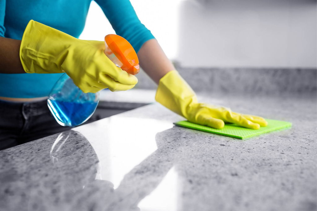 A close-up view of a woman cleaning a kitchen worktop