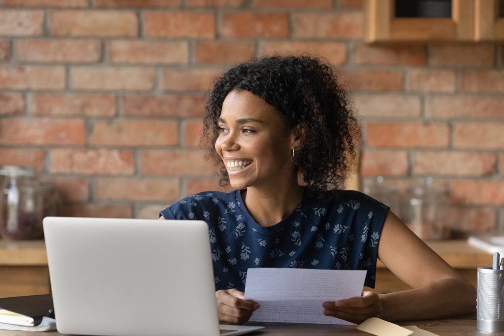 A young woman sat at a desk reading a document.